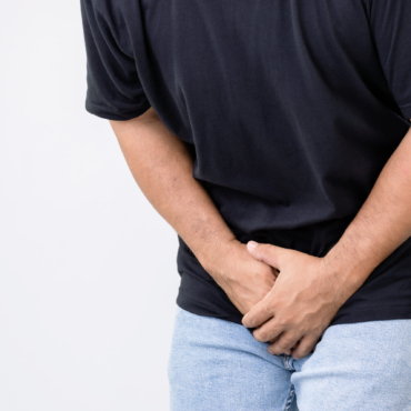 Pain on penis concept : Man use his hands to press on his penis on grey background. Used for Prostate cancer